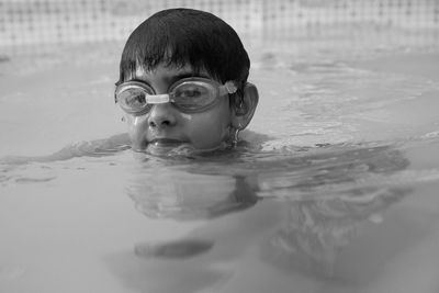 Portrait of shirtless boy swimming in pool