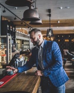 Businessman having coffee at checkout counter in restaurant