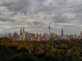 View of buildings in city against cloudy sky