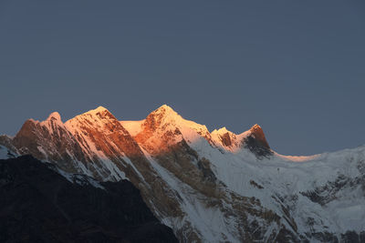 Scenic view of snowcapped mountains against clear sky