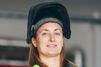 Portrait of smiling female worker wearing welding mask