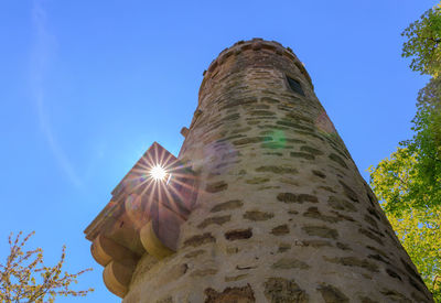 Low angle view of trees against blue sky