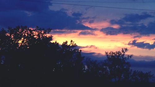 Silhouette of trees against cloudy sky