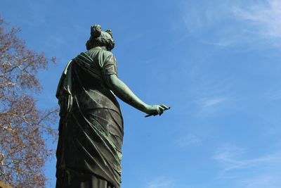 Low angle view of statue against blue sky