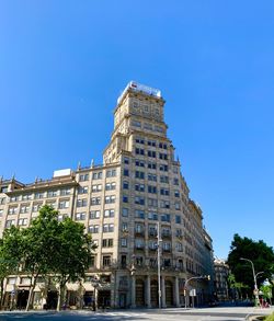 Low angle view of buildings against clear blue sky