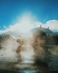 Man swimming in water against sky
