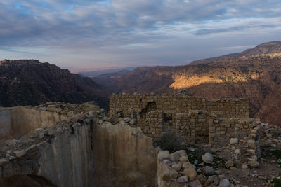 View of rocky mountains against cloudy sky