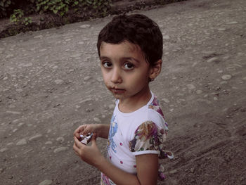 Portrait of cute boy standing on road