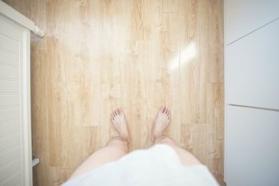 Low section of man standing on floorboard