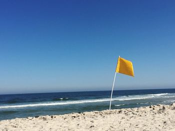 Scenic view of beach against blue sky