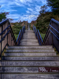 Staircase by bridge against sky