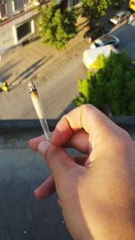 Close-up of hand holding cigarette