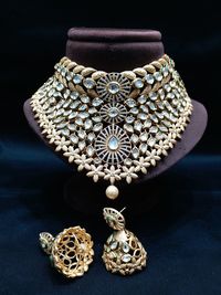 Close-up of jewelry on table against black background