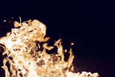 Close-up of illuminated lamp over black background