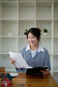 Portrait of young woman using digital tablet in office