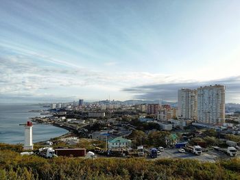 High angle view of buildings by sea against sky