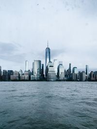 Buildings by sea against sky in city