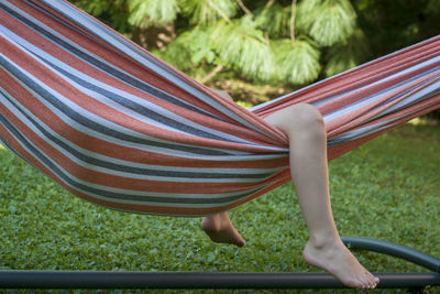 Low section of child relaxing in hammock