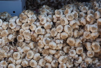 Stacked garlic for sale at market stall