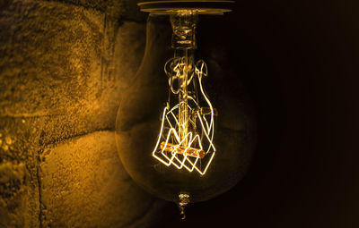 Close-up of illuminated lamp against black background