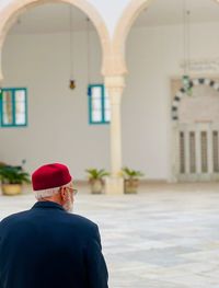Rear view of man standing against historic building