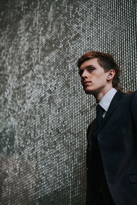 Handsome man standing against wall