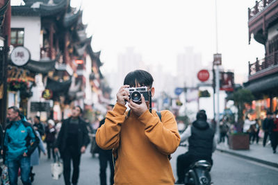 Man photographing on city street