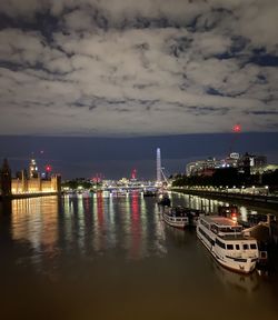 Picture from lambeth bridge along the thames at night with prluament building and river boats 