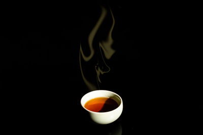 Close-up of coffee cup against black background