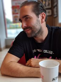 Man with drink looking away on table