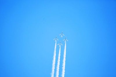 Low angle view of trees against clear blue sky