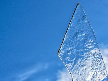 Low angle view of icicles against clear blue sky