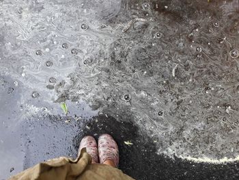 Low section of man standing on beach