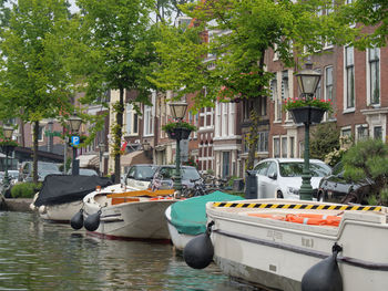 Boats moored in canal by buildings in city