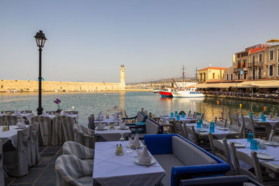 Boats on sea by buildings against clear sky in city