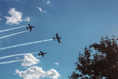 Low angle view of airplane flying in blue sky