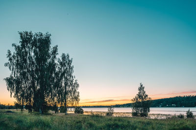 Scenic view of lake against clear sky during sunset