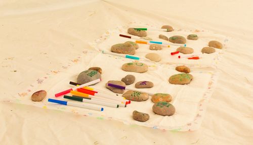 High angle view of stones and felt tip pens on sand