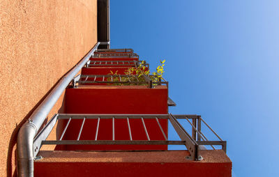 Low angle view of balconies against clear blue sky