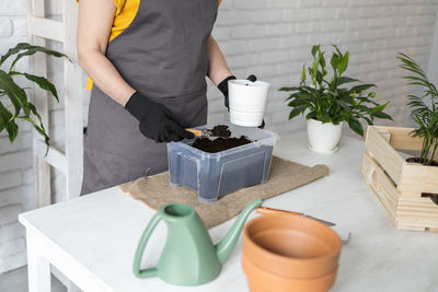 Midsection of woman holding coffee on table