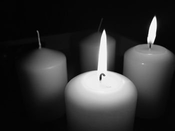 Close-up of lit candles in darkroom