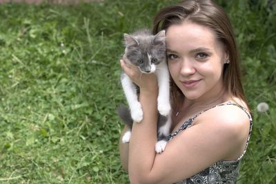 Portrait of smiling young woman holding cat