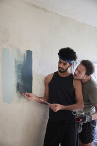 Gay couple renovating flat and choosing wall paint