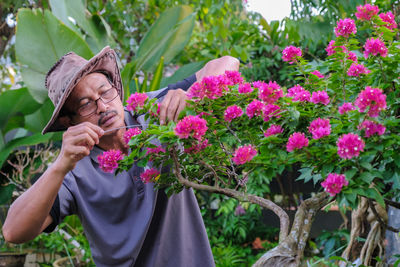 Rear view of woman with pink flowering plants