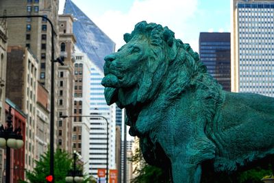 Low angle view of statue against buildings in city