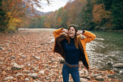 Full length of young woman standing during autumn