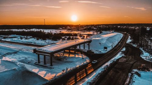 High angle view of frozen river against sky during sunset