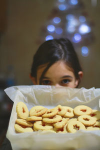 Close-up portrait of girl with cookies at home