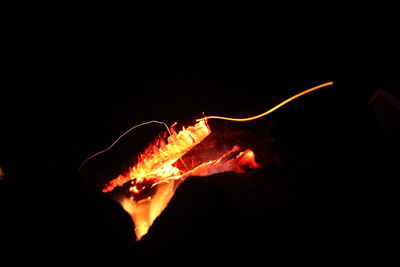 Close-up of light bulb over black background