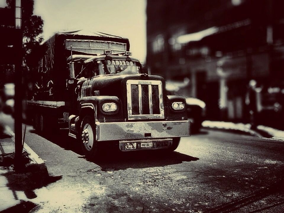 land vehicle, transportation, car, building exterior, mode of transport, street, built structure, architecture, incidental people, city, day, outdoors, focus on foreground, stationary, parking, road, sunlight, bicycle